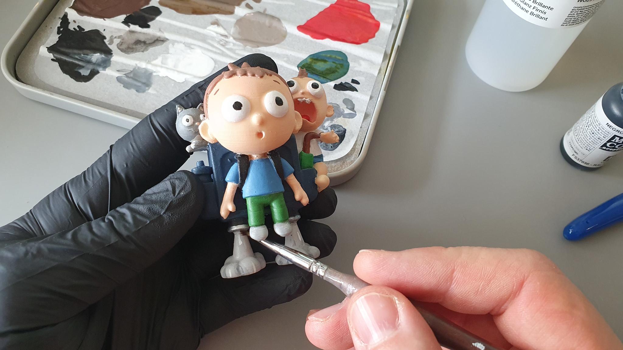 Careful hand-painting of a family figurine during restoration