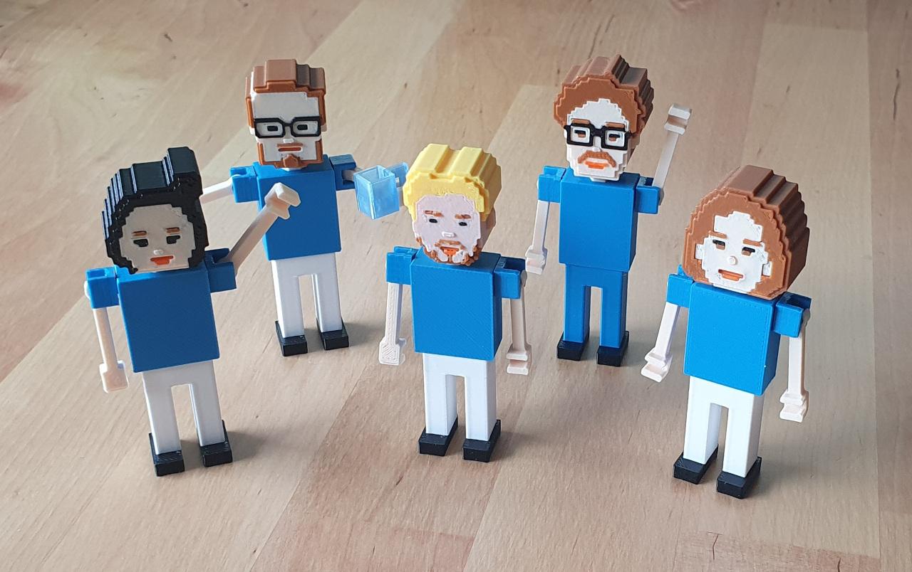 A team of five finished Voxel People figurines on a wooden desk